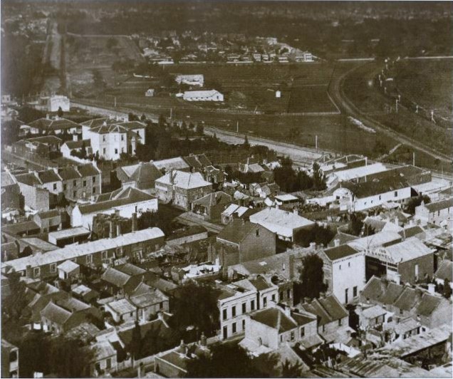 Circa 1870 Looking towards Jolimont, the corner of Flinders St. and Wellington Pde. The East Melbourne C.G. is visible with National Gynasium building next door which was relocated to this site in 1870. City to Richmond railway line with Jolimont Street rail crossing gates.
Photo possibly taken from the Melbourne Town Hall.
Image from publication, The Streets of Melbourne. Herald and Weekly Times for Victoria's 150th Anniversary